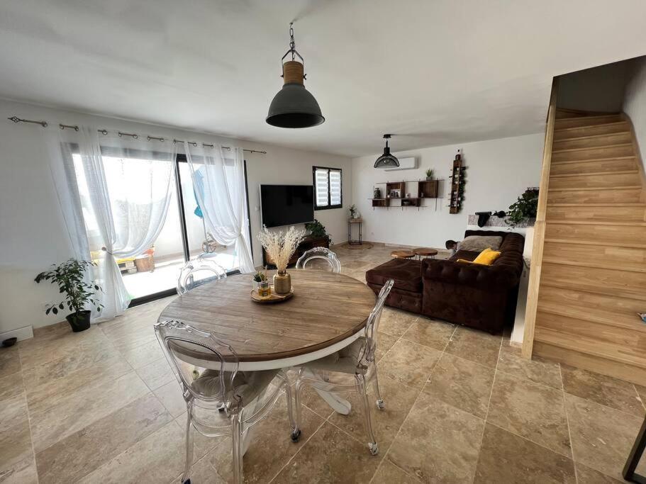 un salon avec une table et un canapé dans l'établissement Charmante maison de village, à Vauvert