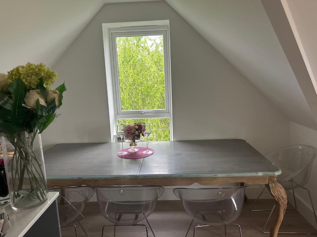 a table with a vase of flowers and a window at The Penthouse Double Bedroom for Rent Free Parking in Epsom