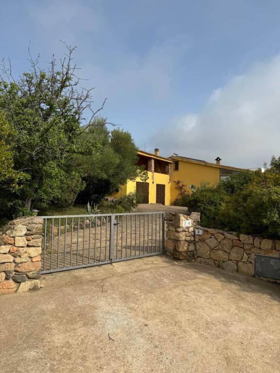 a gate in front of a house with a stone wall at Casa Punta Ruinas in Olbia