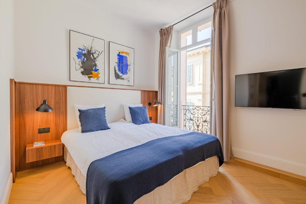 une chambre avec un lit et une grande fenêtre dans l'établissement La Guitare 24 - Nice studio in center of Cannes, just behind Grand Hotel, à Cannes
