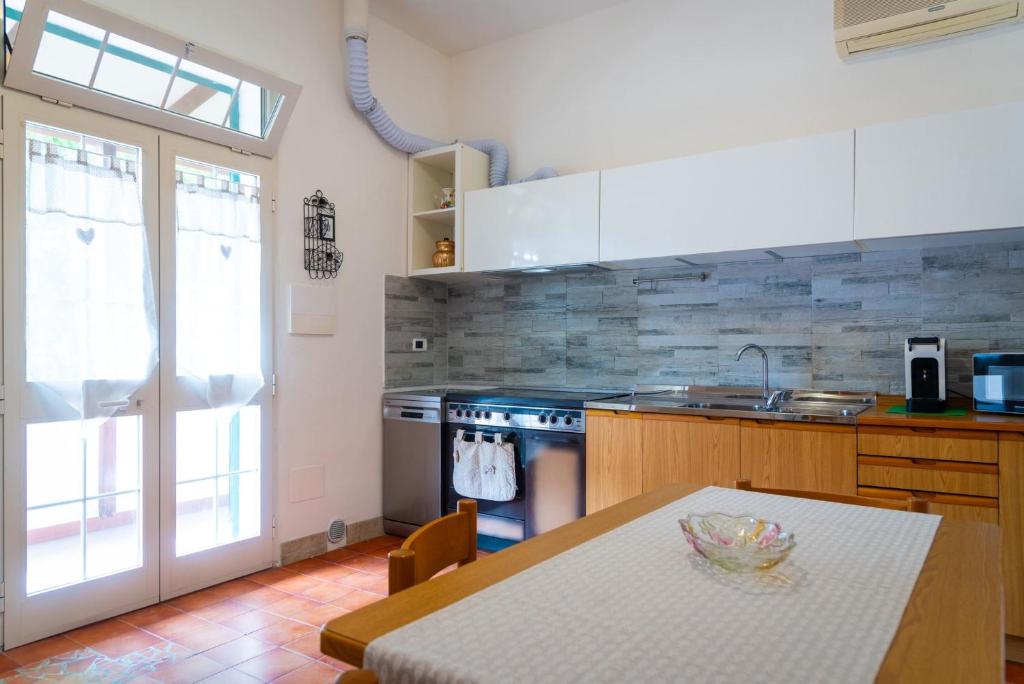 Una cocina con una mesa, un fregadero y una estufa. en Appartamento Terrazza, en Portoferraio