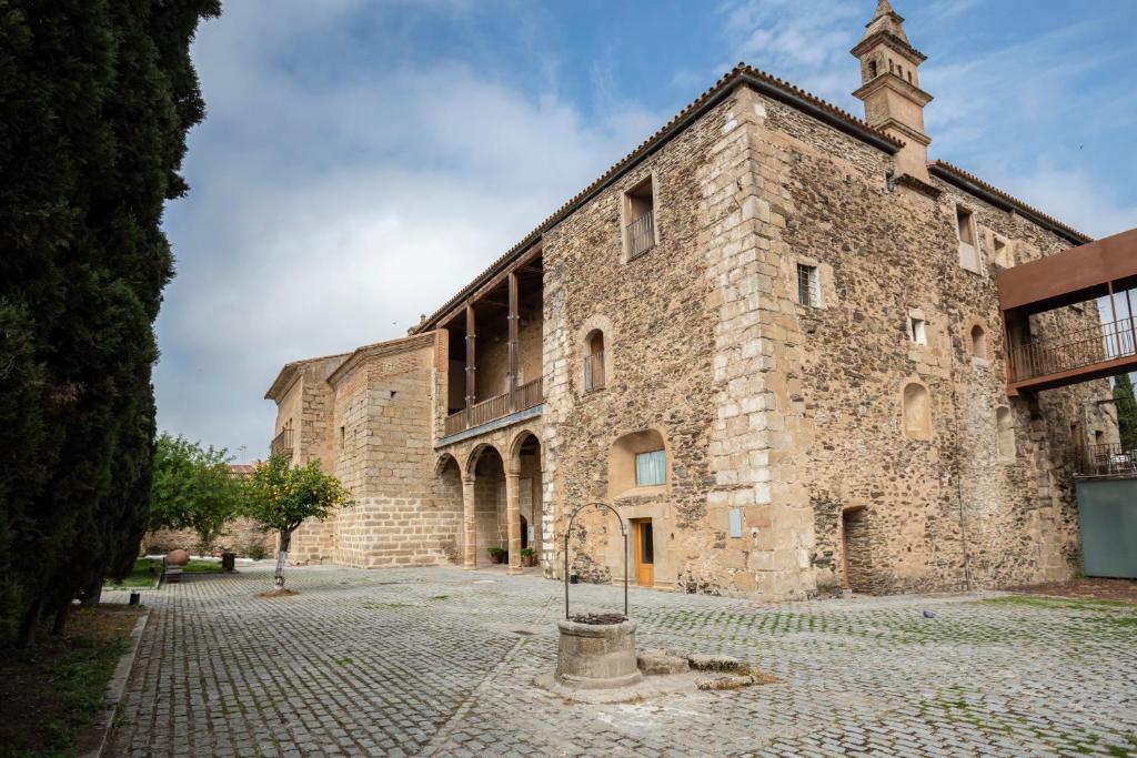 a large stone building with a tower on top at Hotel Puente de Alconétar in Garrovillas
