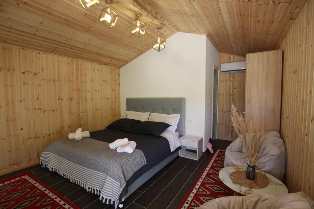 a bedroom with a bed in a room with wooden walls at Lugina e Shengjergjit ,Bujtinat in Tirana