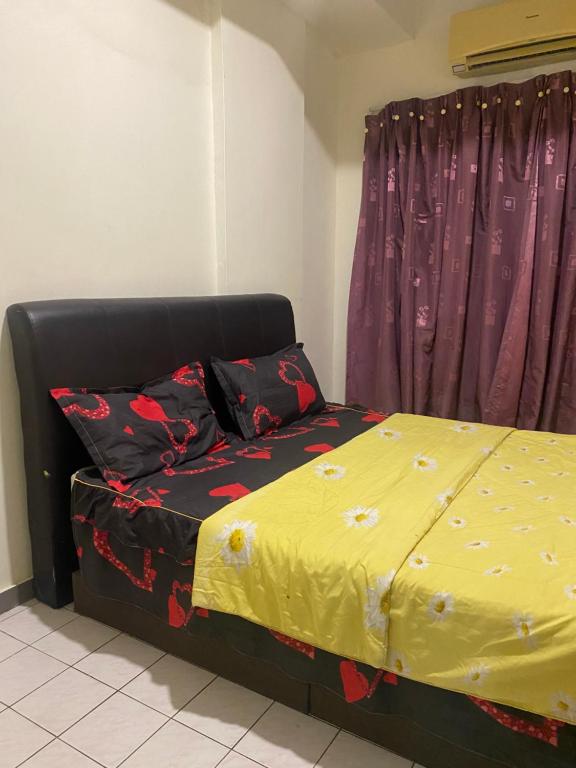 um quarto com uma cama com um cobertor amarelo em PD Seaview Paradise Lagoon Apartment em Porto Dickson