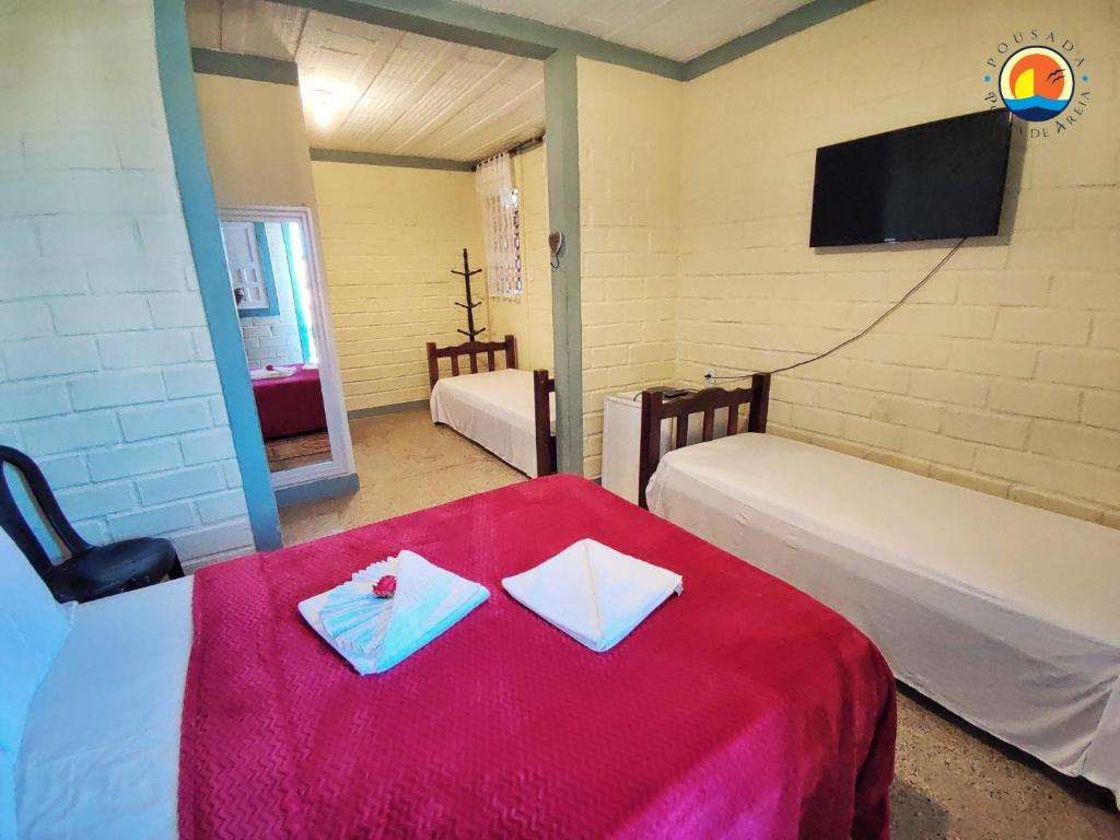 維拉維爾哈的住宿－Pousada Ponta de Areia，客房设有红色桌子、两张床和电视。