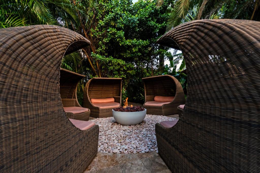 two wicker chairs and a fire pit in a garden at The Standard Miami in Miami Beach