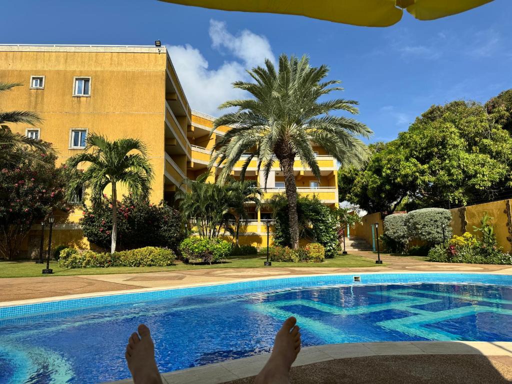 a person laying on a bed next to a swimming pool at Luxury condominio Tatramar in La Sabana
