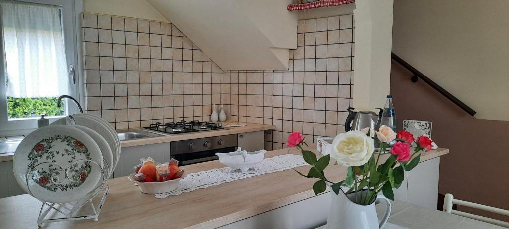 uma cozinha com um vaso de flores num balcão em Ildi's Guest House em Seriate