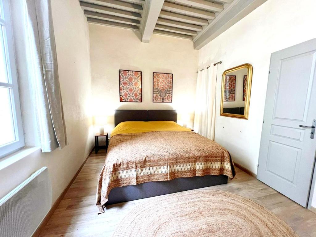 a bedroom with a bed with a yellow blanket at La Picholine in Uzès