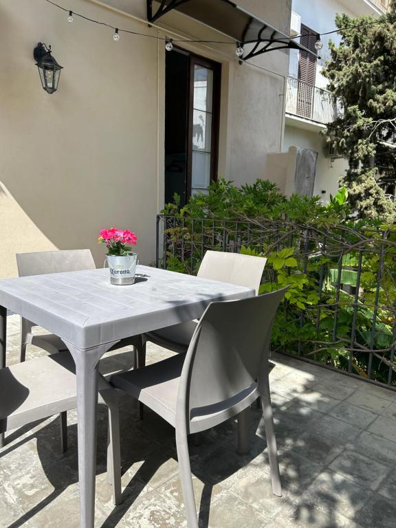 uma mesa branca e cadeiras com flores num pátio em Casa MiRè em Catânia