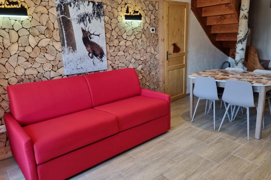 a red couch in a living room with a table at Estatico 1 - T2 duplex apartment sleeps 4 in Névache