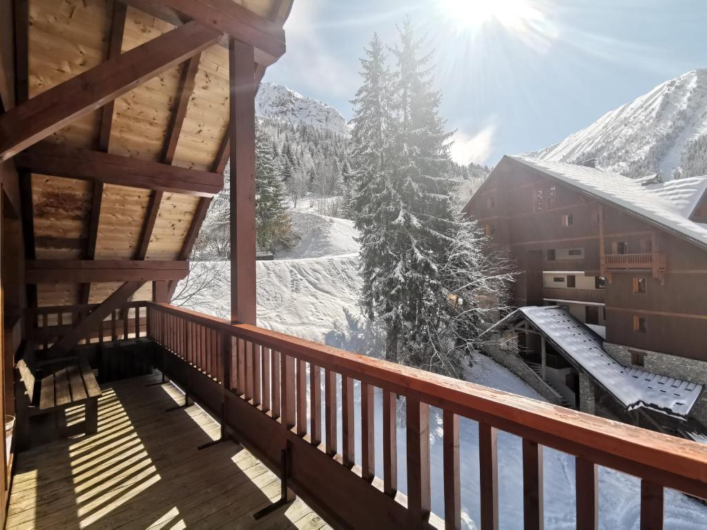 - une vue sur l'hiver depuis le balcon d'une cabane en rondins dans l'établissement Ski in & out spacious apartment, Sauna-Gym-Piscine, à Oz