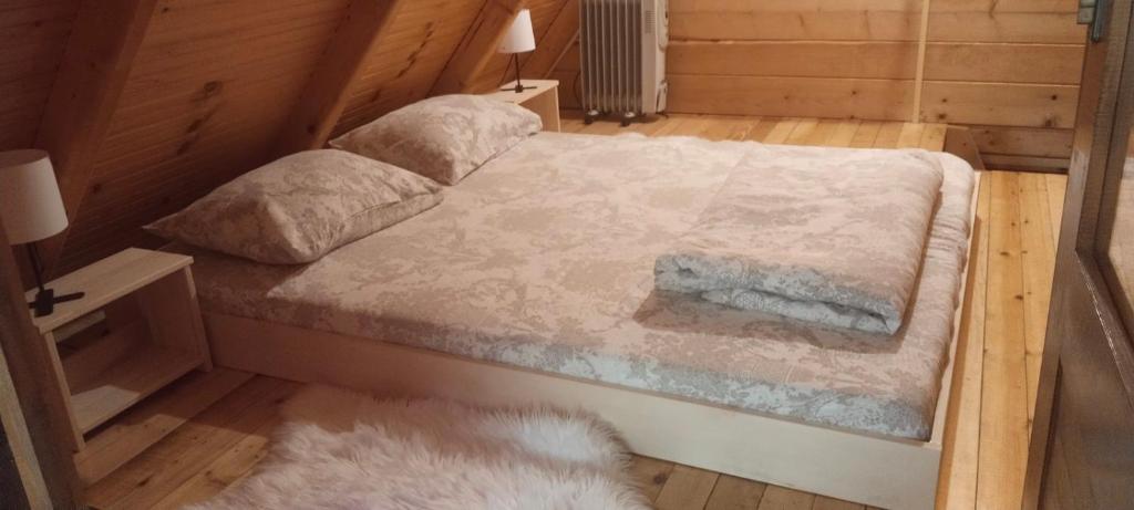 um quarto com uma cama com um edredão branco em Brvnara Morava em Ovcar Banja