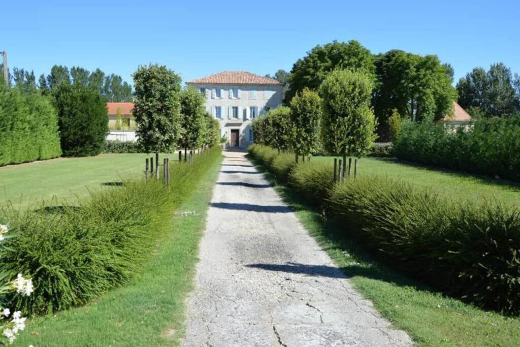 une route en gravier avec une maison en arrière-plan dans l'établissement Maison : L'Appart des Anges 10 personnes, à Althen-des-Paluds