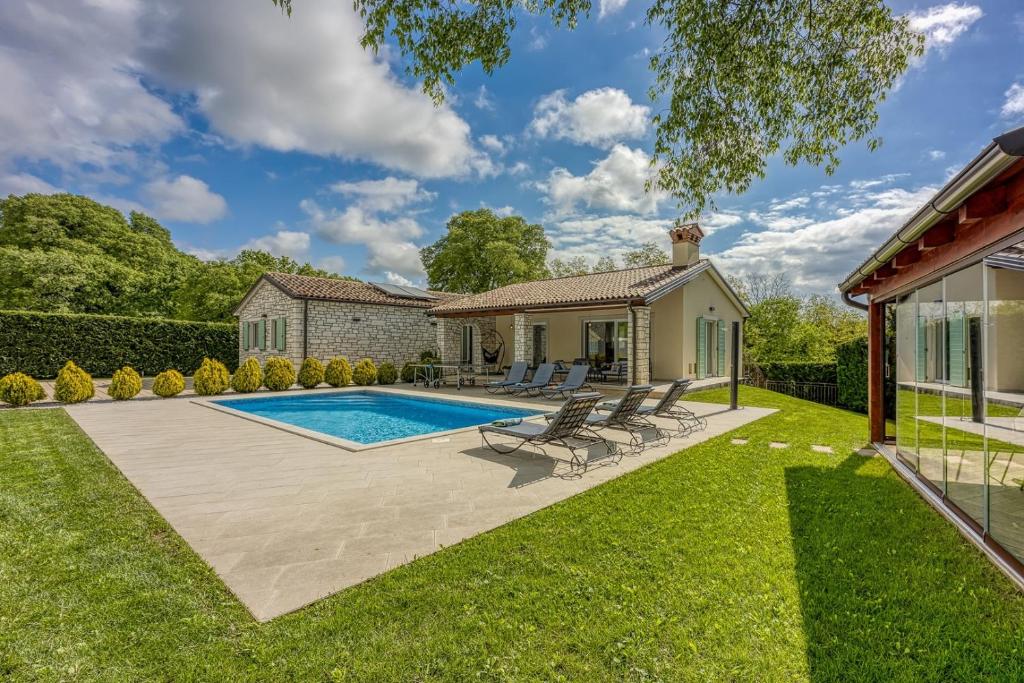 un patio trasero con piscina y césped en Celtis House -Pool-Whirlpool-Sauna, en Grožnjan