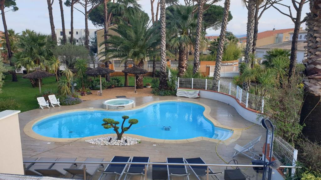 - une piscine dans un complexe avec des palmiers dans l'établissement ARGELES sur MER APPT ETAGE CALELLA TOUT CONFORT JARDIN PISCINE PARKING WIFI, à Argelès-sur-Mer