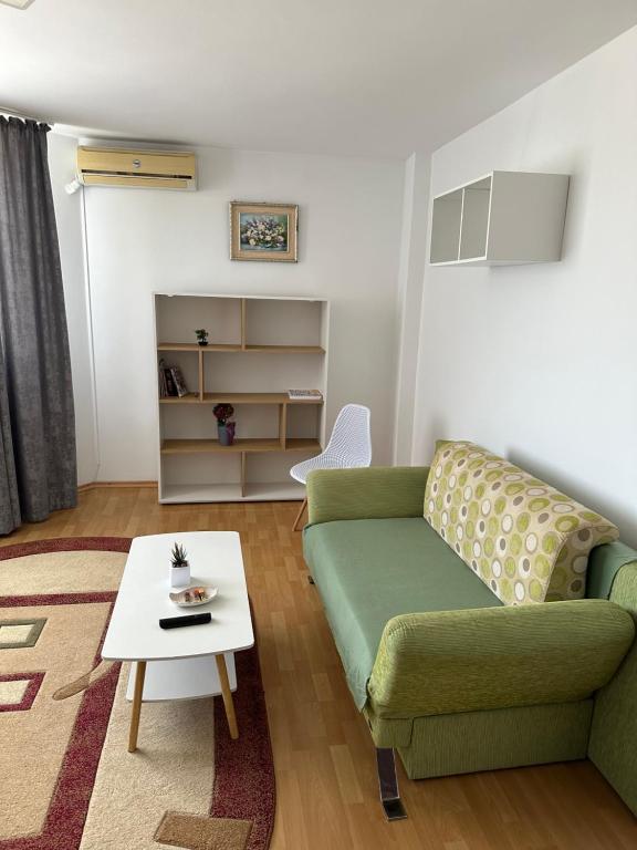 salon z zieloną kanapą i stołem w obiekcie Apartament Amalia w mieście Roman