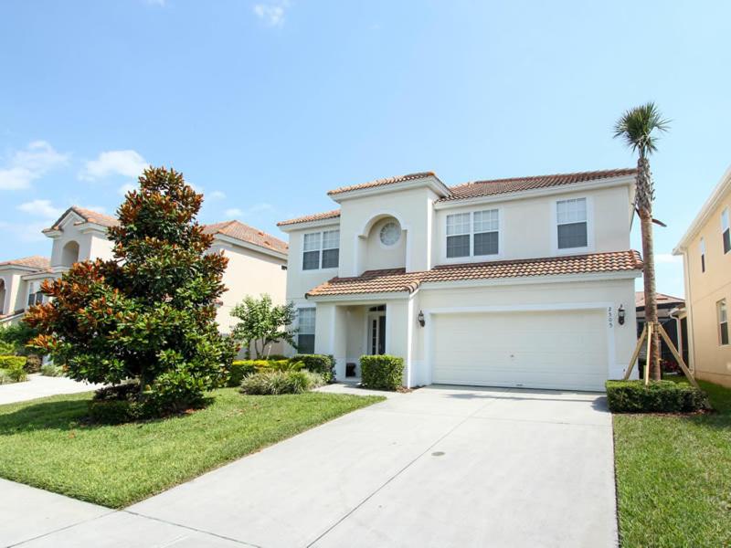 uma casa branca com uma garagem e uma palmeira em Archfeld Villa 2505 em Orlando