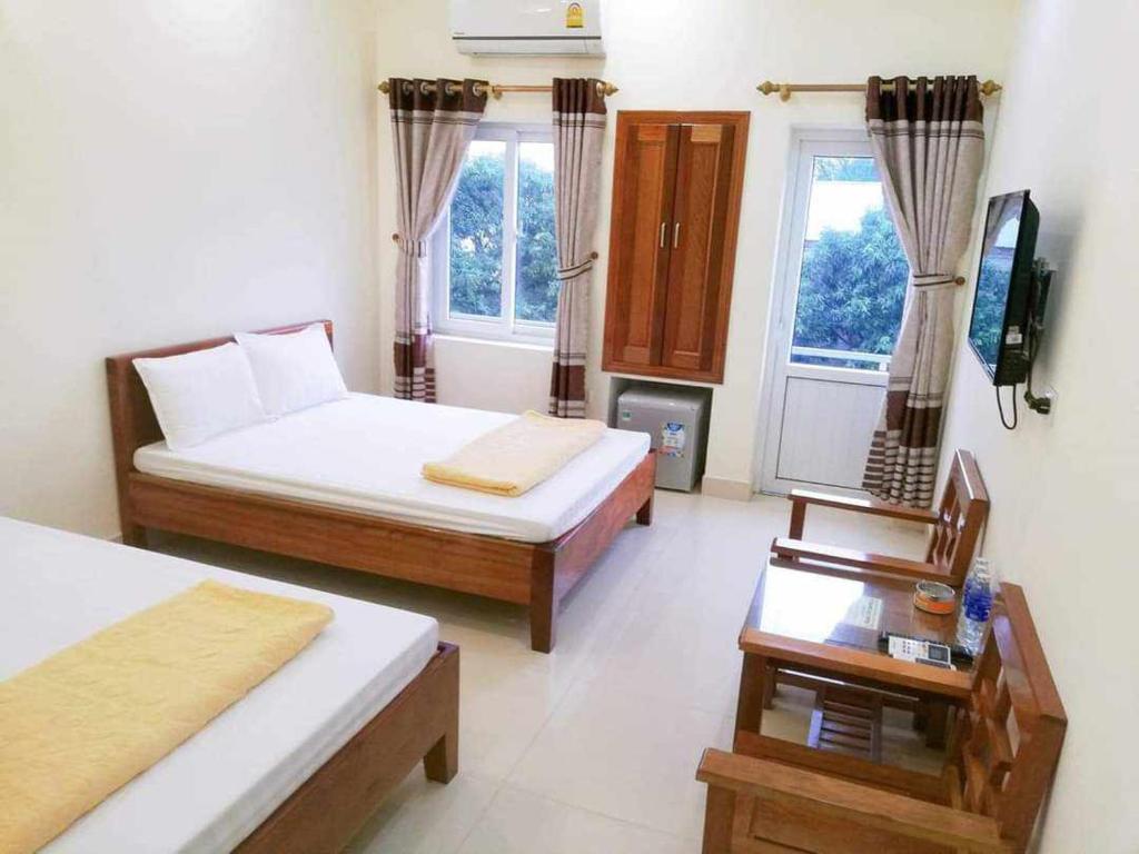1 dormitorio con 2 camas y TV. en Khách Sạn Thành Đạt, en Thương Xà (2)