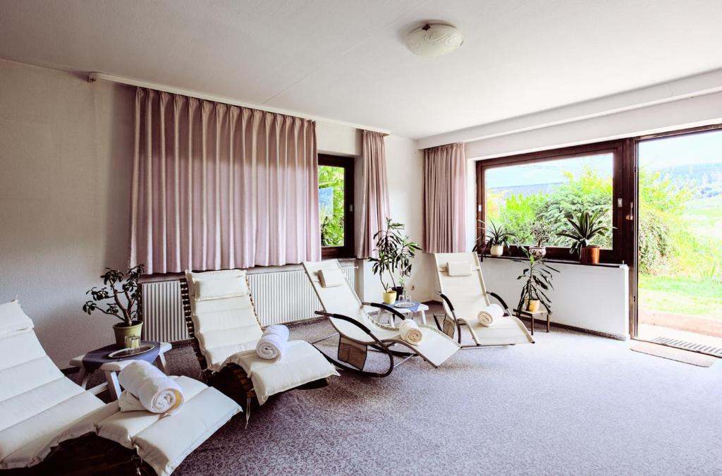 Hotel Schauinsland في باد بيترستال غريسب: غرفة معيشة وكراسي بيضاء ونافذة كبيرة