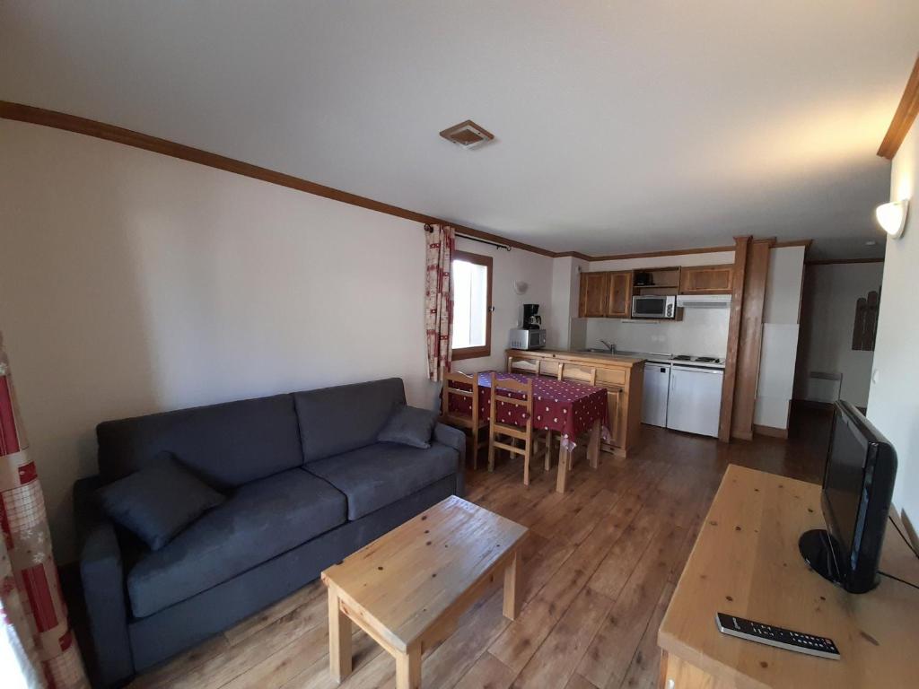 uma sala de estar com um sofá azul e uma mesa em Appartement Aussois, 4 pièces, 6 personnes - FR-1-508-279 em Aussois