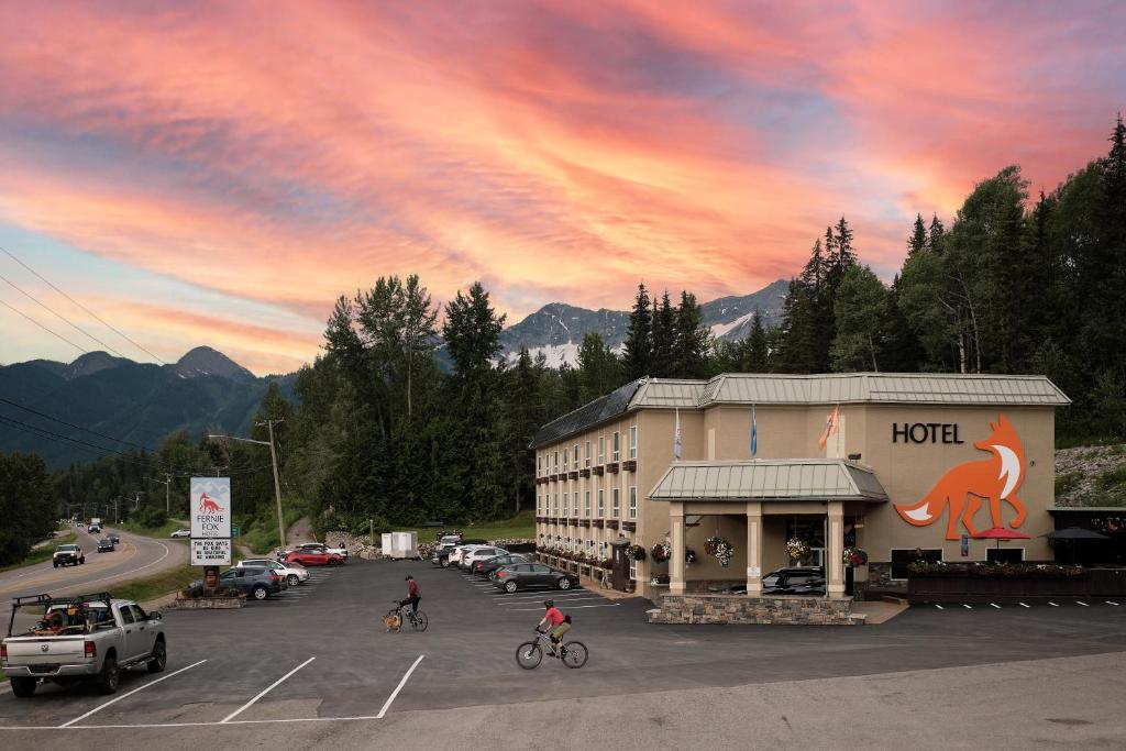 a hotel with people riding bikes in a parking lot at Fernie Fox Hotel in Fernie