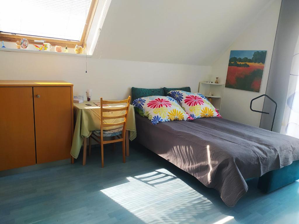 ein Schlafzimmer mit einem Bett und einem Tisch mit einem Stuhl in der Unterkunft Wohnung auf 2 Ebenen in Leopoldshöhe