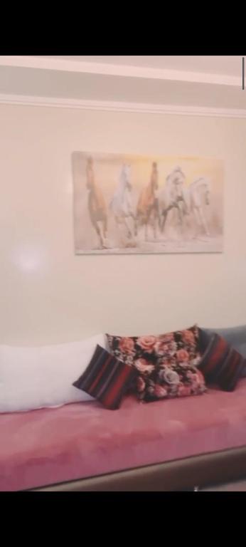 a bed with a picture on the wall and two pillows at Hay Mohammadi agadir in Agadir