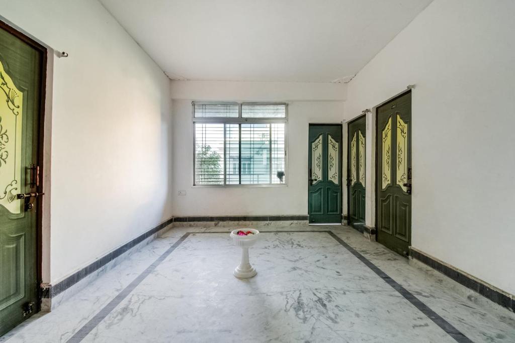 een lege kamer met groene deuren en een vaas op de vloer bij SPOT ON Hotel Rakesh International in Dānāpur