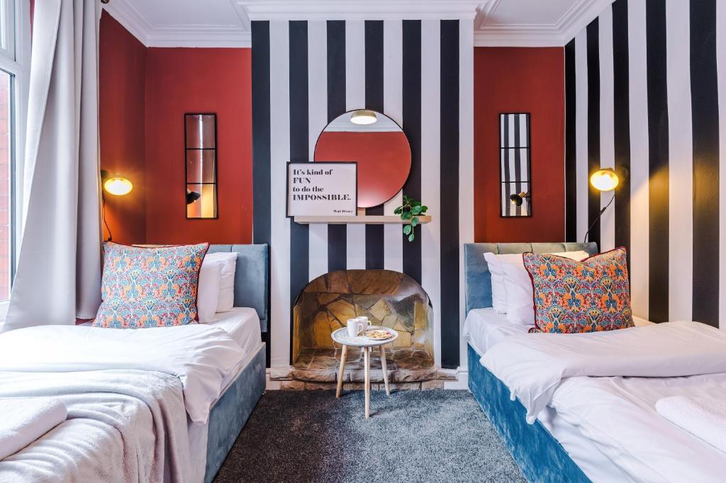 Duas camas num quarto com lareira em Charming 3-Bedroom House-Salford em Manchester
