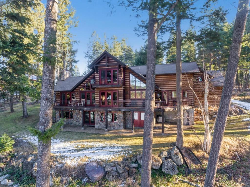 a log home in the woods with trees at Lake View Escape in Whitefish