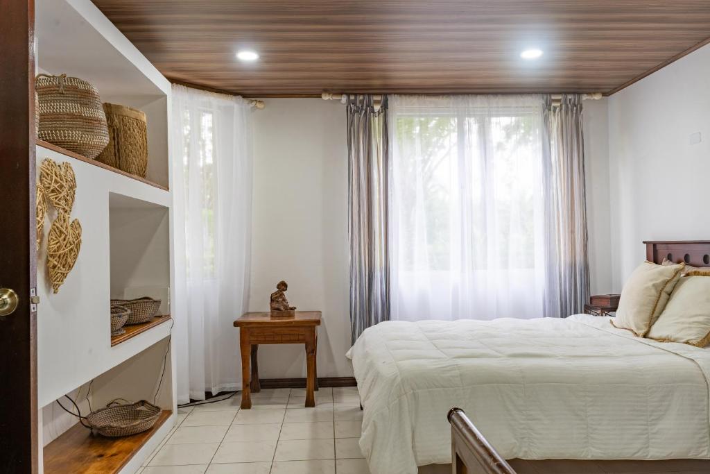 um quarto com uma cama branca e uma janela em Family 2bd apt near Quepos/Manuel Antonio em Quepos