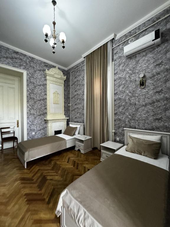 a bedroom with two beds and a brick wall at Vintage Boutique Hostel in Baku