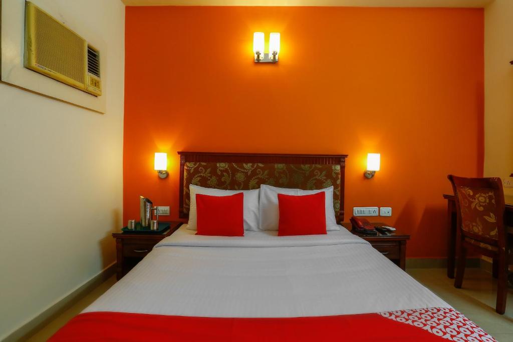 a bedroom with a large bed with red pillows at Collection O Mamieyaar Veedu in Chennai