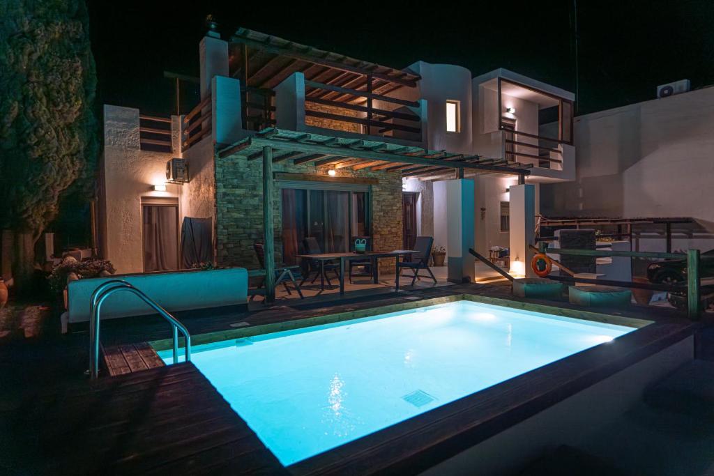 a swimming pool in front of a house at night at Apollonas & Sibylla Villa in Kalymnos
