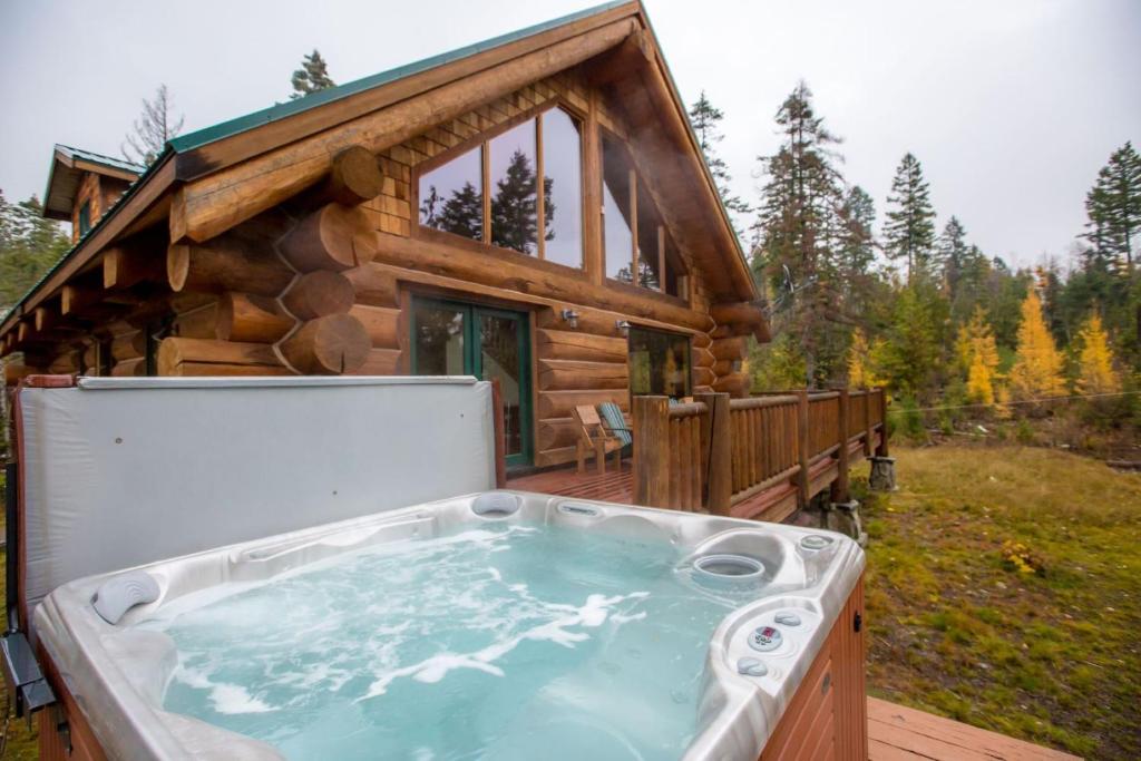 einen Whirlpool auf dem Deck einer Blockhütte in der Unterkunft Hellroaring Hut in Whitefish