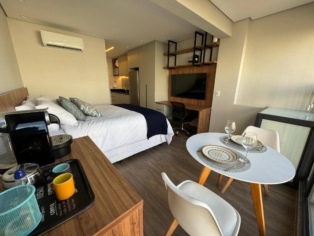 une chambre d'hôtel avec un lit, une table et des chaises dans l'établissement 915 Lux Studio Allianz Park, à São Paulo
