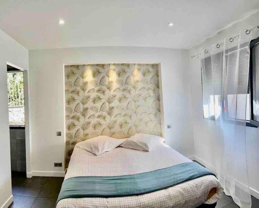 1 dormitorio con 1 cama con una pared grande en Villa contemporaine avec piscine, en Bidart