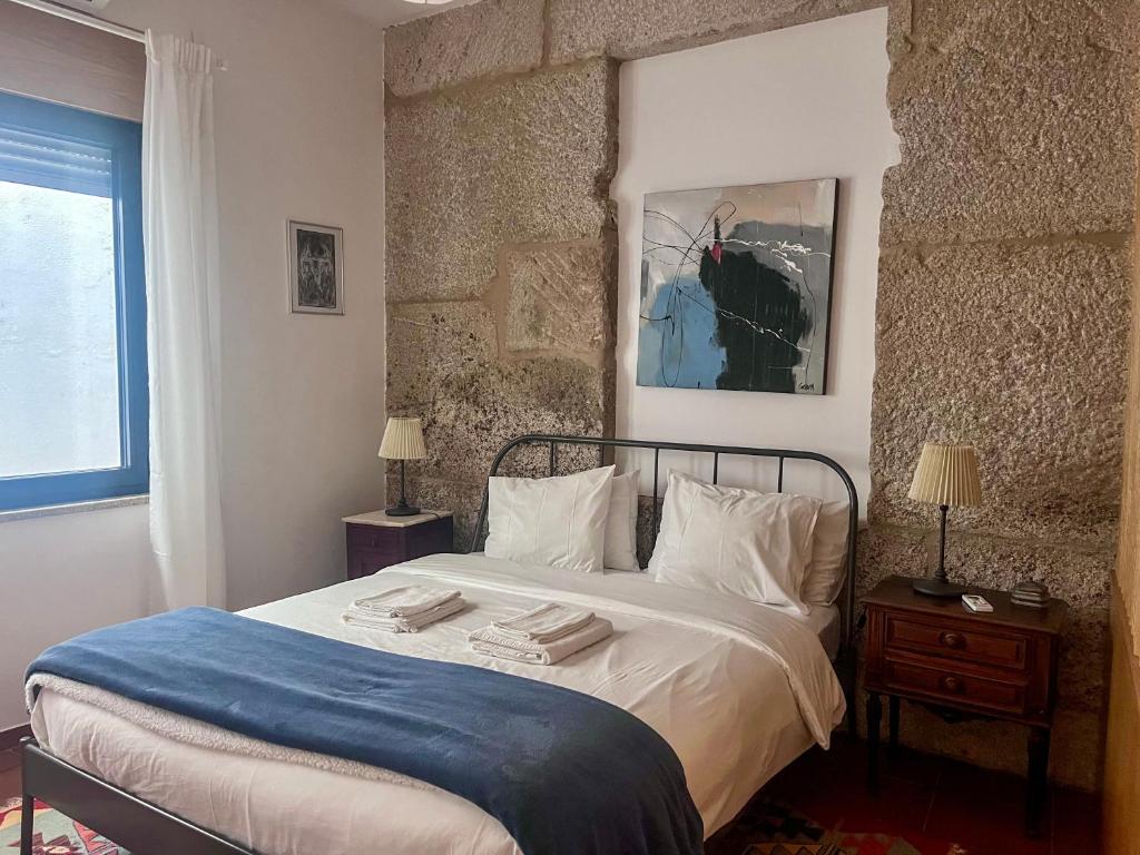 ein Schlafzimmer mit einem Bett mit zwei Handtüchern darauf in der Unterkunft Imperial Douro Apartamento 2 in Peso da Régua