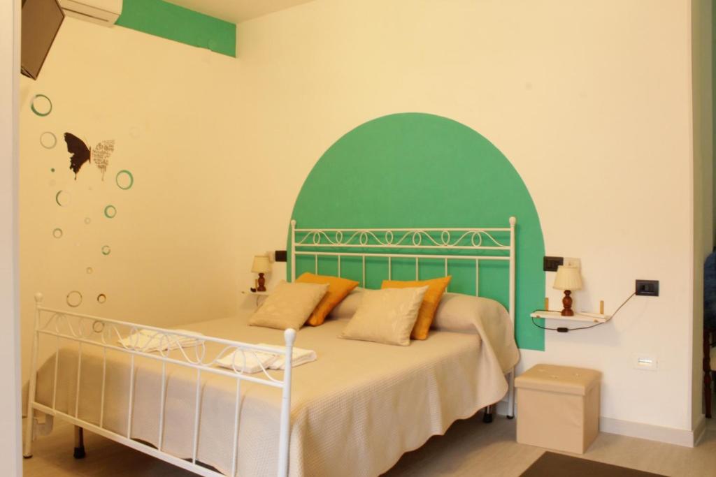 um quarto com uma cama com uma cabeceira verde em Maya guest house em Vietri