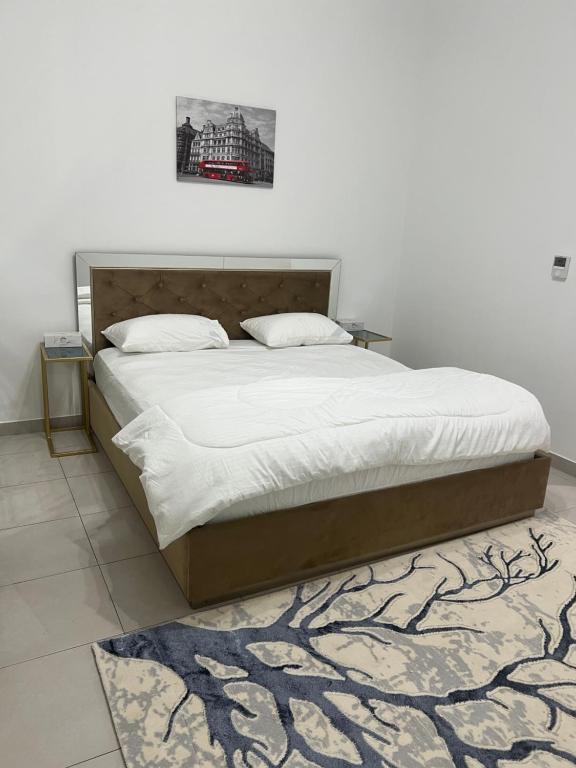 a bedroom with a large bed with white sheets and a rug at Dubai Entire Serviced Room Unit Excellence in Dubai