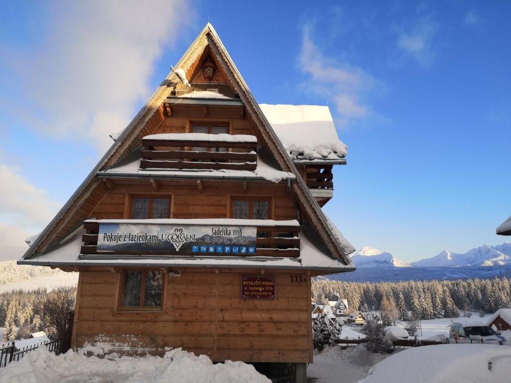 Cabaña de madera con nieve en el techo en Ośrodek Wczasowy U Góralki en Murzasichle