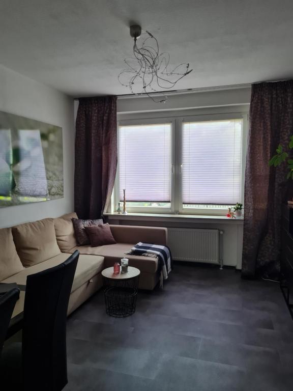 uma sala de estar com um sofá e uma grande janela em Ferienwohnung in Fuldatal bei Kassel em Fuldatal
