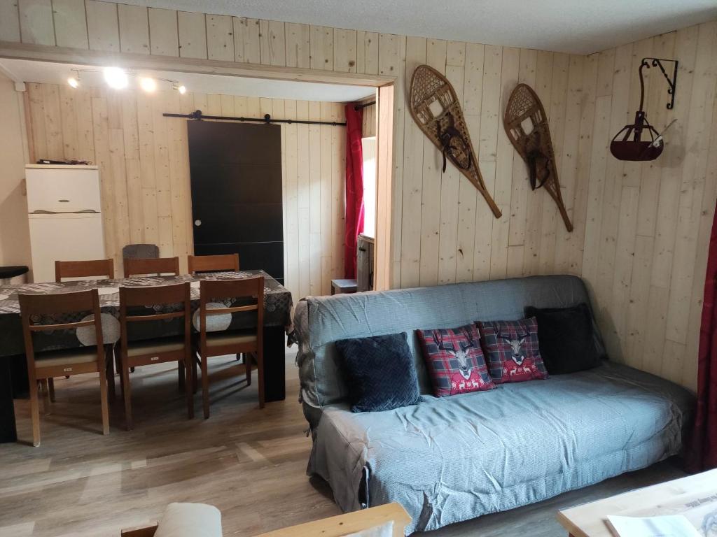 een woonkamer met een bank en een eetkamer bij Les digitales appartement in Mont-Dore