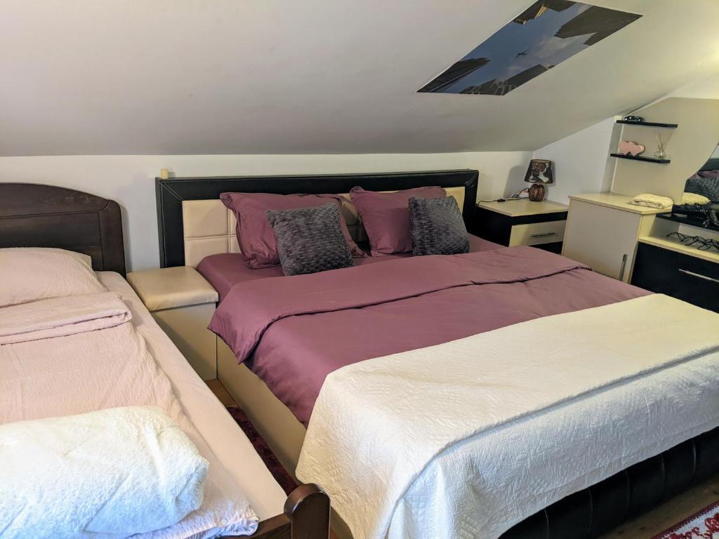 een slaapkamer met 2 bedden met paarse en witte lakens bij Apartman Hrastik 2 in Bihać