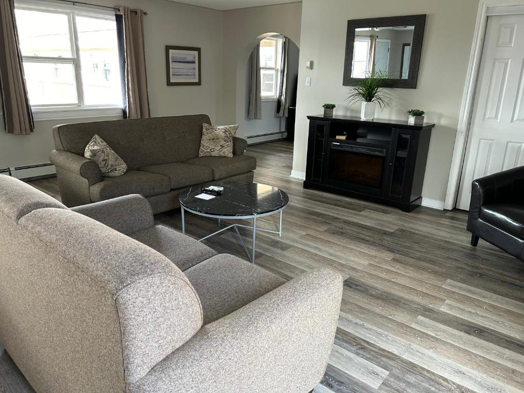 a living room with two couches and a table at Middleton Motel & Suites in Middleton