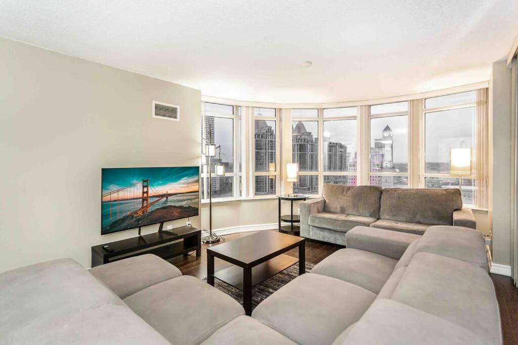 a living room with a couch and a large window at High-end 2BR/2BA Condo+Views!-Steps from SQ1 Mall in Mississauga