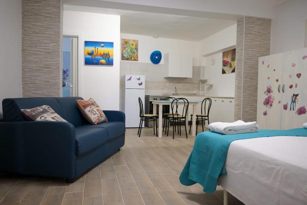 een woonkamer met een blauwe bank en een keuken bij Casa vacanze Elvy e Uccio 2 in Nardò