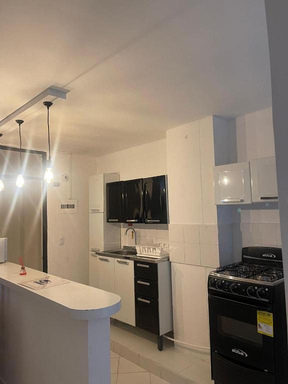a kitchen with black and white appliances and a counter at Apartamento 202 in Itagüí