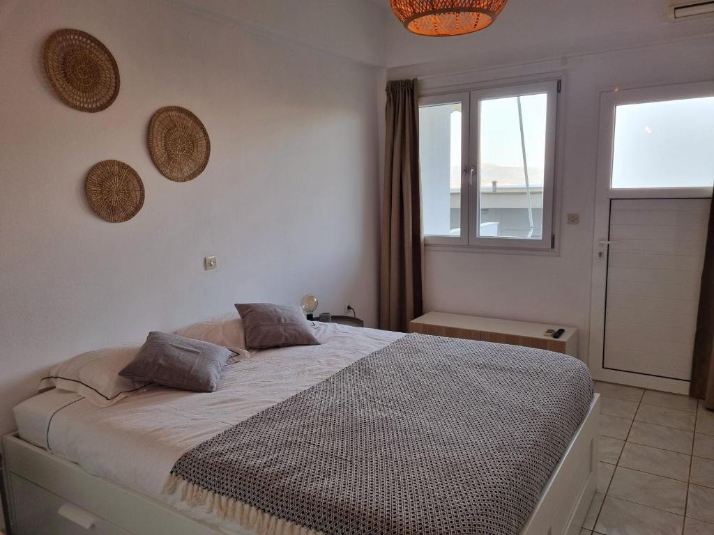 a bedroom with a large bed and a window at Tolo at sea - Nova in Tolo